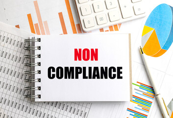 Notebook with text non compliance on financial documents with charts, pen and calculator