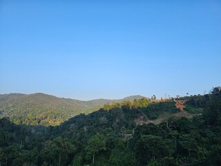 Obraz premium A scenic view of lush green mountains under a clear blue sky, showcasing the beauty of nature and tranquility.