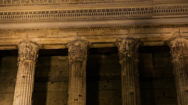 night time ancient corinthian columns fluted shafts worn acanthus capitals warm amber moldings illuminate piazza di pietra / temple hadrian up close rome italy roman empire emperor 