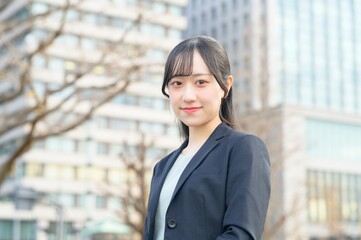 Fototapeta premium オフィス街とスーツのビジネスウーマン