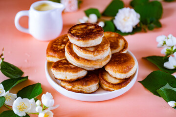 Fritters on a white plate on a pink background for breakfast. Delicious fritters for dessert. Close-up