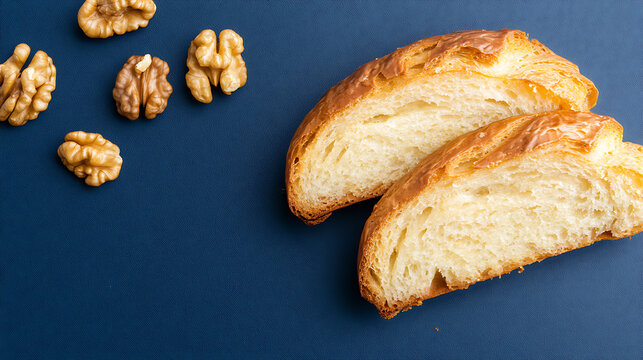 Two slices of golden-crusted bread alongside shelled walnuts on a smooth, deep blue surface, creating a simple yet appetizing visual. Food photography.