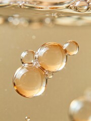 Abstract macro photo of golden oil bubbles floating in clear liquid on a soft beige background. Minimal cosmetic texture concept for skincare, spa, beauty and wellness design.
