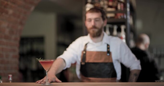 Barman prepares a cocktail with focus on technique in a lively bar setting during evening hours