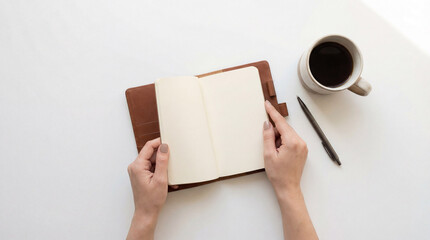 Blank notebook lies beside hot coffee. Notebook page stays empty for New Year planning, bullet journal notes, back to school goals, minimal desk with pen, copy space, calm morning concept