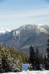 Beautiful panorama of high rocky mountains with snowy peaks against the blue sky and clouds. Brandnertal, Austria