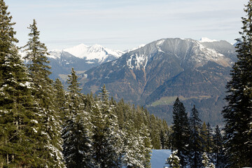 Beautiful panorama of high rocky mountains with snowy peaks against the blue sky and clouds. Brandnertal, Austria
