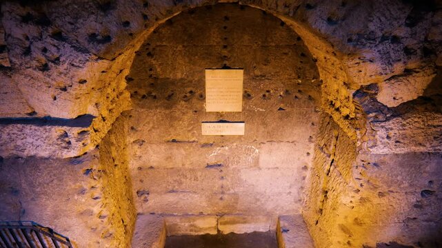 arched ancient stone niche carved into rough roman masonry chisel marks latin inscription plaques solemn chamber exists castel sant'angelo rome italy empire emperor 