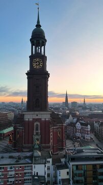 Vertical aerial drone footage (rotating) of the famous St. Michaelis Church at sunrise in Hamburg