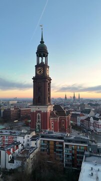Vertical aerial drone video (rotating) of the famous St. Michaelis Church at sunrise in Hamburg