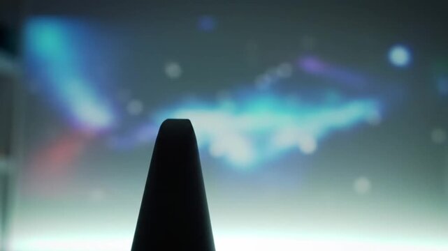 Dark conical shape stands before a glowing, abstract background.