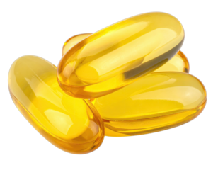 Close-up of glossy, golden-yellow capsules, with soft highlights, scattered on a dark backdrop