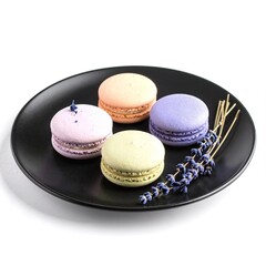 A delicate plate holds three colorful macarons&mdash;pistachio green, raspberry pink, and vanilla cream&mdash;surrounded by fragrant sprigs of lavender.