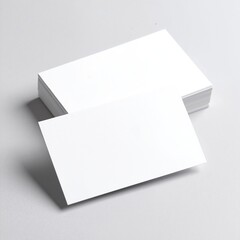 Two pristine white business cards elegantly placed on a textured grey background, showcasing their clean design and professional appeal.