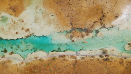 Top view of visitors swimming in Bacalar channel with clear blue water and boardwalk.
