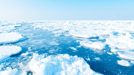 Arctic ocean surface with numerous ice floes floating on freezing water under a clear blue sky