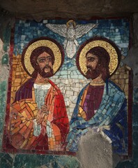 Naklejka premium Two men are depicted in a mosaic, one holding a bird. The men are dressed in red and blue, and the bird is white. Concept of peace and harmony, as the men