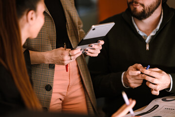 Business team discussing ideas and strategies in a modern office setting during a midday meeting with digital devices and documents present