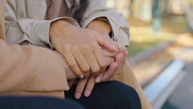 Close up unrecognizable couple holding hands in city supporting gesture unknown man cold with woman warming help consoling affectionate bonding sign female male palms boyfriend girlfriend family love