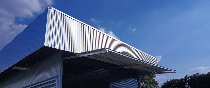 Metal sheet roof curve on blue sky. Modern construction, Metal ribbed arch span roof covering, Large building roof. not ai