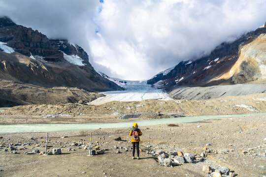 Tourist admiring athabasca glacier in jasper national park, alberta