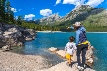 Mother and son admiring lake minnewanka in banff national park, canada