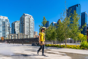 Tourist walking in calgary's east village neighborhood on a sunny day