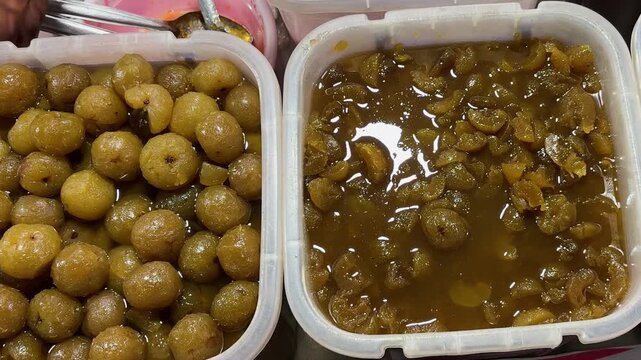 traditional indian amla pickle and sweet murabba in plastic containers for retail sale