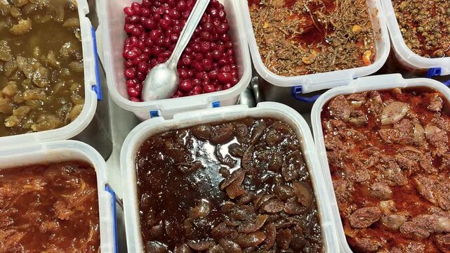 assorted indian pickles and chutneys in plastic containers at street shop for sale