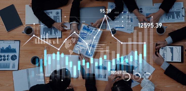 A team of business professionals engages in deep analysis of financial data while reviewing diverse graphs and charts on wooden table in a collaborative environment. Scalp - Powered by Adobe