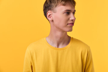 Male wearing a yellow shirt against a bright yellow background, simple studio setup, clean lines,...