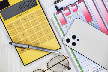 Business and accounting supplies arranged in a composition on an office desk. Top view.