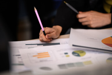 Hands engaged in discussion with charts and reports during a collaborative meeting in an office setting
