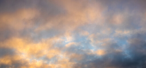 Obraz premium Gentle blue sky with soft yellow clouds at dawn, pastel atmospheric landscape with blurred cloud formations and calm mood