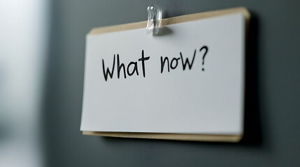 A note pinned with "What now?" written on it prompts reflection and consideration. It symbolizes decision-making moments, inviting contemplation of options and future actions.
