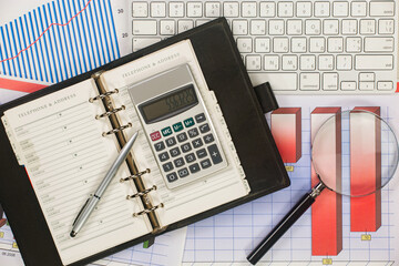 Business and accounting supplies arranged in a composition on an office desk. Top view.