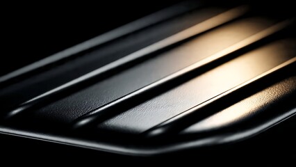 Close-up of a sleek, dark metallic surface with prominent parallel ridges and dynamic light reflections, creating an abstract and sophisticated textured background for modern design concepts