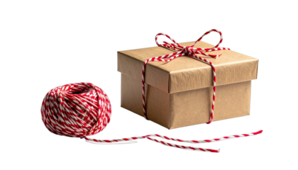 A simple brown gift box tied with red and white baker's twine next to a ball of matching twine on a black background.