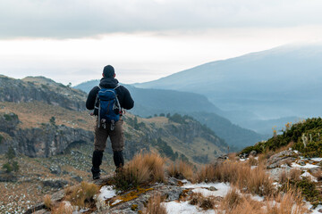 Hiker looking at iztaccihuatl volcano in winter