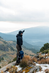 Man hiking high mountain pointing achieving adventure goals