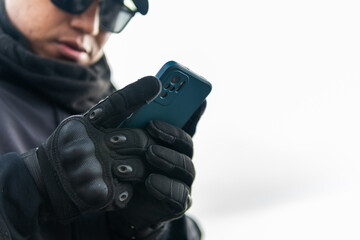 Man in tactical gloves reading smartphone outdoors