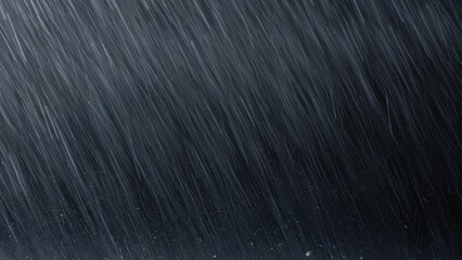 Heavy rain streaks diagonally across a dark, moody background during a severe downpour.