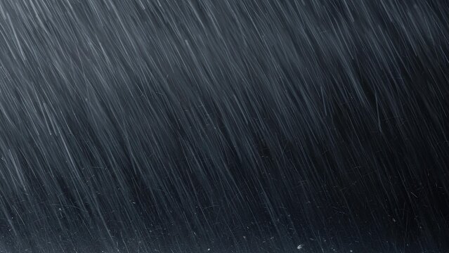Heavy rain streaks diagonally across a dark, moody background during a severe downpour.
