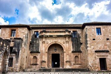 Ornate stone church building facade with carved entrance under cloudy sky