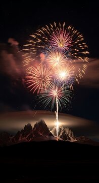 Fireworks display over mountain landscape at night.