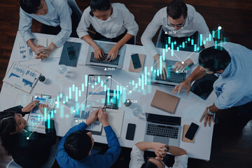 A diverse group of professionals collaborates in a modern office setting, analyzing data on laptops with financial graphs to drive business strategies and decisions. Trope