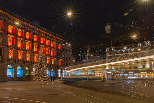 Zurich, Switzerland - December 25.2025:  The Christmas illumination on the Parade Square (Paradeplatz) with a passing bus in Zurich.