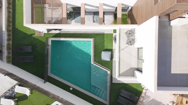 Modern villa with private pool and rooftop solar panels viewed from drone above