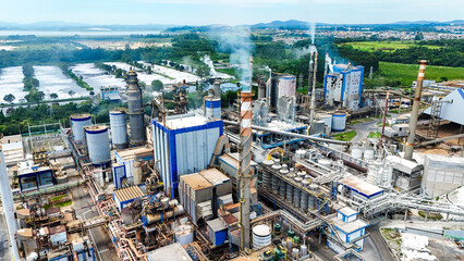 Ind&uacute;stria de papel e celulose com tanques, torres e equipamentos de processamento, representando produ&ccedil;&atilde;o em escala industrial e a base do setor manufatureiro.