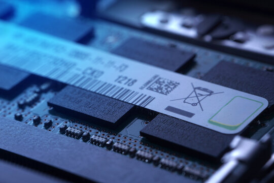 Artistic macro photography of a RAM module illuminated by blue light. Highlights the intricate circuitry and silicon chips with a futuristic, high-tech cybersecurity aesthetic.